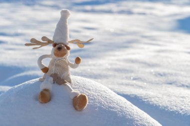 Karlı arazideki Noel geyiği figürü. Komik kış günü ve Noel ruhu kavramı.