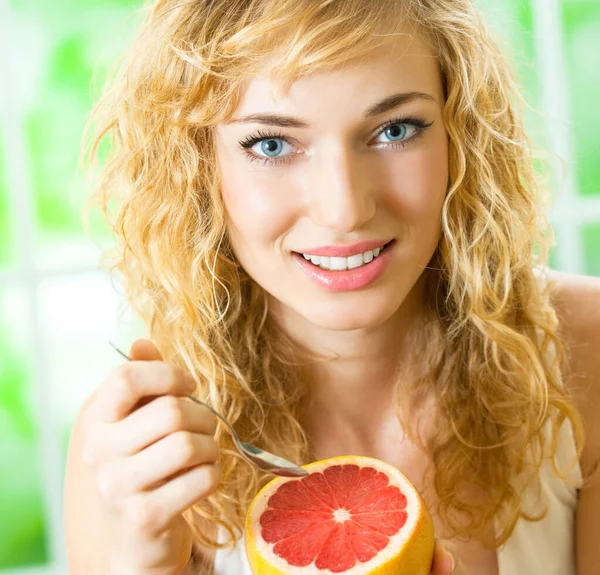Fröhliche Blonde Frau Isst Grapefruit — Stockfoto