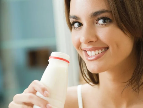 年轻快乐的女人在家里喝牛奶的肖像 — 图库照片