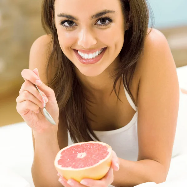 自宅でグレープ フルーツを食べる若い女性の Portarit — ストック写真