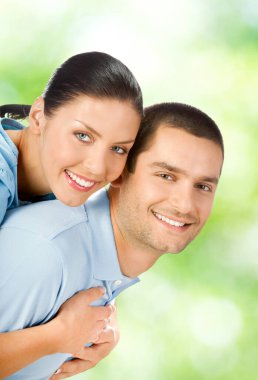 genç çekici sevdalı kucaklayan bir çift, açık havada gülümseyerek mutlu bir portresi