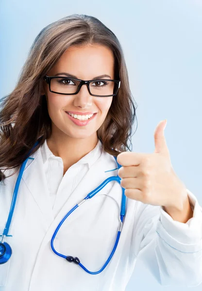 快乐微笑开朗的女医生与姿态 竖起大拇指对蓝色背景 — 图库照片