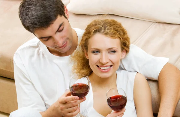 屋内赤ワインのグラスで陽気な笑みを浮かべてカップルの肖像画 — ストック写真