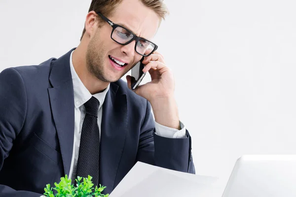 年轻快乐的笑脸商人 戴着眼镜 身穿黑色西服 在办公室里与手机和笔记本电脑一起工作 工作和教育概念方面的成功 — 图库照片