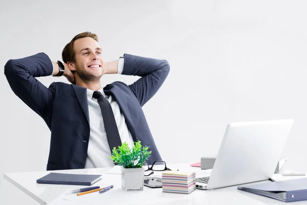 开心的笑着放松或梦想着的生意人 双手放在脑后 身穿黑色西服 在办公室用笔记本电脑工作 工作和教育概念方面的成功 — 图库照片