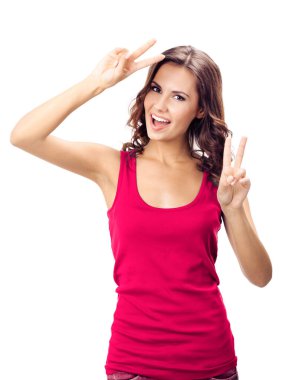 Mutlu, güler yüzlü kırmızı elbiseli genç bir kadın, iki parmağını ya da zafer jestini gösteriyor, beyaz arka planda izole edilmiş.