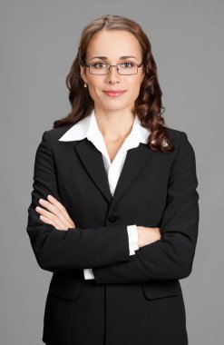 gri arka plan üzerinde mutlu gülümseyen genç iş kadını portresi