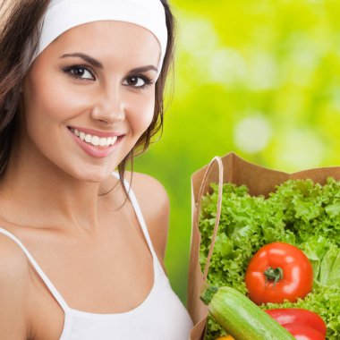 bakkal alışveriş çantası ile sağlıklı vejetaryen yemekleri, açık havada tutan fitness giyim mutlu gülümseyen genç güzel kadın portresi