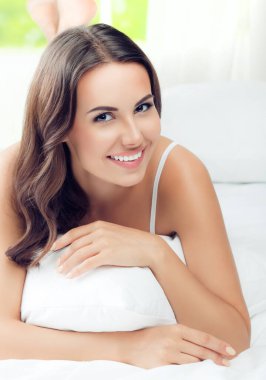 Genç güzel kadın esmer yastık, yatak, ile uyanma