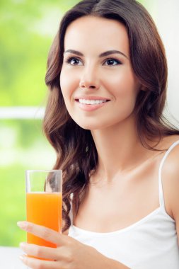Portakal suyu içme mutlu gülümseyen genç güzel esmer kadın portresi. Sağlıklı beslenme, güzellik ve kavram diyet.