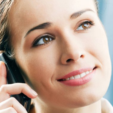 mutlu neşeli genç iş kadını ofiste cep telefonu ile gülümseyen
