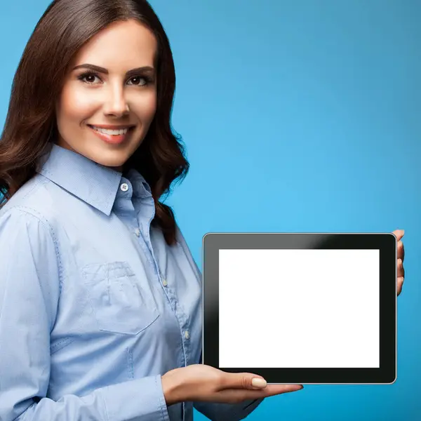 年轻迷人的女商人开心地笑着 带着蓝色背景的空白无名氏平板电脑显示器 还有一些文字 广告或标语的复制空间 免版税图库图片