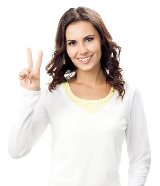 笑容满面的年轻女子露出两根手指或胜利的姿态 与白色背景隔离 图库照片