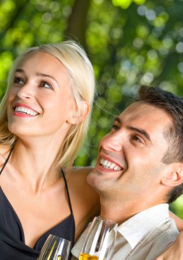 genç gülümseyen çekici çift bardak şampanya, açık kutluyor mutlu