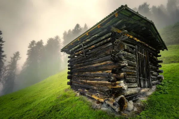 stock image Mountain wooden hayloft in the Stubai Alps with fog in the background