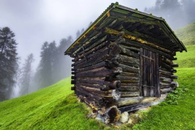 Stubai Alpleri 'ndeki dağ ahşap samanlığı. Arka planda sis var.