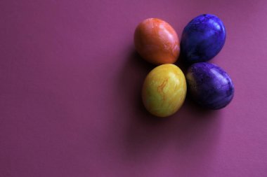 Renkli arka planda farklı renkte Paskalya yumurtaları.