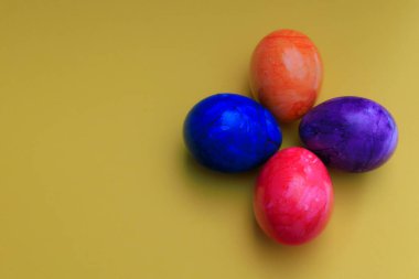 Renkli arka planda farklı renkte Paskalya yumurtaları.