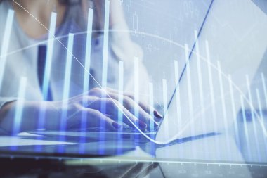 Bilgisayarda ve finansal grafik hologramında kadın eli yazarken çift pozlama. Borsa analizi kavramı.