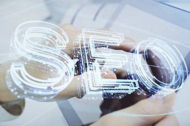 Dijital bir cihaz ve seo çizimi kullanan bir adamın el ele tutuşması. arama optimizasyonu kavramı.