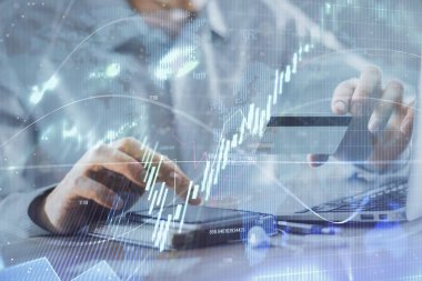 Ellerinde kredi kartı ve forex çizimi olan bir adamın çift pozu. İnternet E-ticaret kavramında hisse senedi ve dijital fintech.