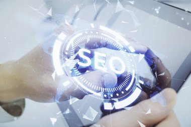 Dijital bir cihaz ve seo çizimi kullanan bir adamın el ele tutuşması. arama optimizasyonu kavramı.