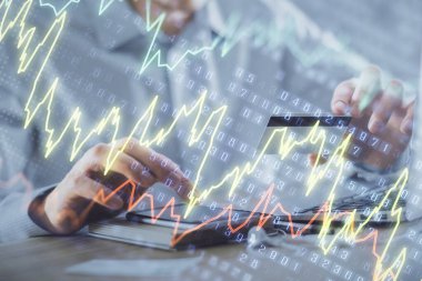 Ellerinde kredi kartı ve forex çizimi olan bir adamın çift pozu. İnternet E-ticaret kavramında hisse senedi ve dijital fintech.