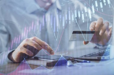 Ellerinde kredi kartı ve forex çizimi olan bir adamın çift pozu. İnternet E-ticaret kavramında hisse senedi ve dijital fintech.