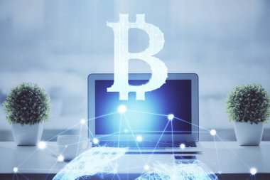 Engelleme zinciri ve kripto ekonomi temalı hologram ve bilgisayar geçmişi olan bir masa. Bitcoin kripto para kavramı.