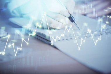 Bir kadın eller Not defteri hisse senedi piyasası hakkında bilgi yazma. Ön Forex grafik hologramlar. Araştırma kavramı. Çoklu pozlama