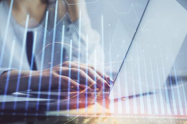 Bilgisayarda ve finansal grafik hologramında kadın eli yazarken çift pozlama. Borsa analizi kavramı.