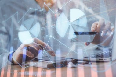 Ellerinde kredi kartı ve forex çizimi olan bir adamın çift pozu. İnternet E-ticaret kavramında hisse senedi ve dijital fintech.