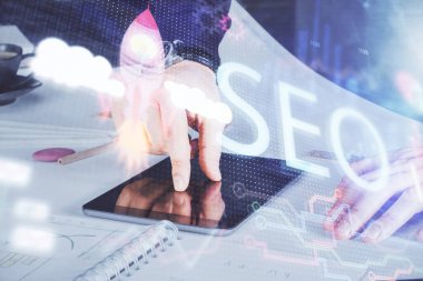 Dijital bir cihaz ve seo çizimi kullanan bir adamın el ele tutuşması. arama optimizasyonu kavramı.