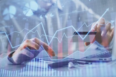Ellerinde kredi kartı ve forex çizimi olan bir adamın çift pozu. İnternet E-ticaret kavramında hisse senedi ve dijital fintech.