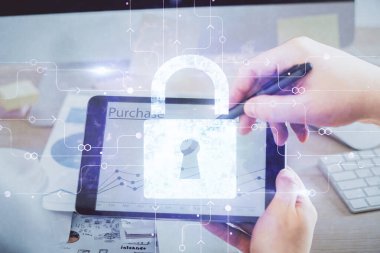 Dijital bir cihaz ve kilit çizimi kullanan bir adamın el ele tutuşması. Güvenlik kavramı.