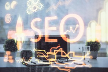 Bilgisayar ve seo çizim hologramı olan bir masanın çifte görüntüsü. Arama optimizasyon kavramı.