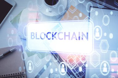 Masaüstü arkaplanındaki bilgisayarın üzerinden engelleme temalı hologram çizimleri. Üst Manzara. Çoklu maruz kalma. Kripto ekonomi kavramı.