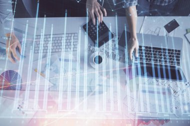 Birlikte çalışan kadın ve erkeğin birden fazla pozu ve finansal grafik hologramı. İş konsepti. Bilgisayar arkaplanı.