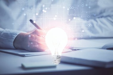 El üstünde tutulan ampul hologramı notlar alıyor. Fikir kavramı. Çift pozlama