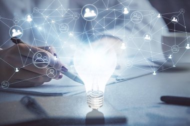 El üstünde tutulan ampul hologramı notlar alıyor. Fikir kavramı. Çift pozlama