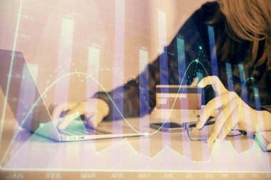 Çevrimiçi alışveriş yapan bir kadının elinde kredi kartı ve mali grafik çizimi tutarken iki kez görüntülenmiş. Borsa E-ticaret kavramı.