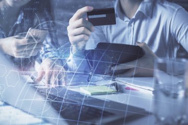 Bir kredi kartı ve hologram çizimi tutan kadın ve erkeğin online alışverişine iki kez maruz kalıyorlar. Uluslararası E-ticaret ödemesi çevrimiçi konsept.