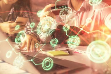 Bir kredi kartı ve sosyal ağ temalı hologram çizimi tutan bir kadın ve erkeğin online alışverişine iki kez maruz kalıyorlar. Bağlayan ve E-ticaret yapan insanlar çevrimiçi konsept üzerinden ödeme yapıyorlar.