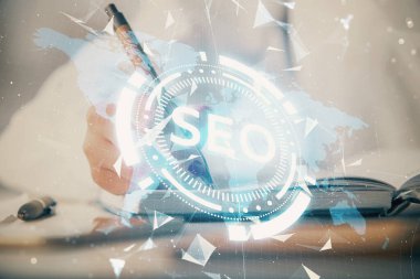 SEO simgesiyle notlar alan bir kadının ellerine iki kez maruz kalmak. Arama motoru optimizasyonu kavramı