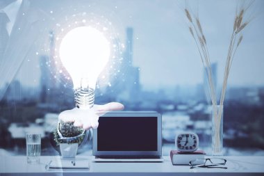 Bilgisayar ofisinde ampul simgesi hologramıyla birlikte. Çifte maruziyet. Fikir kavramı.