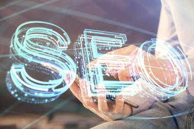Dijital bir cihaz ve seo çizimi kullanan bir adamın el ele tutuşması. arama optimizasyonu kavramı.