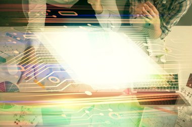 Kadın ve erkeğin birlikte çalışması ve veri temalı hologram çizimi. Bilgisayar arkaplanı. Üst Görünüm.