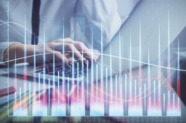 Bilgisayarda ve finansal grafik hologramında kadın eli yazarken çift pozlama. Borsa analizi kavramı.