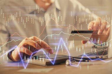 Ellerinde kredi kartı ve forex çizimi olan bir adamın çift pozu. İnternet E-ticaret kavramında hisse senedi ve dijital fintech.