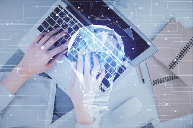 Bilgisayar ve ampul hologramı çizimleri üzerinde çalışan kadın elleri çift pozlama. Üst Manzara. Fikir kavramı.